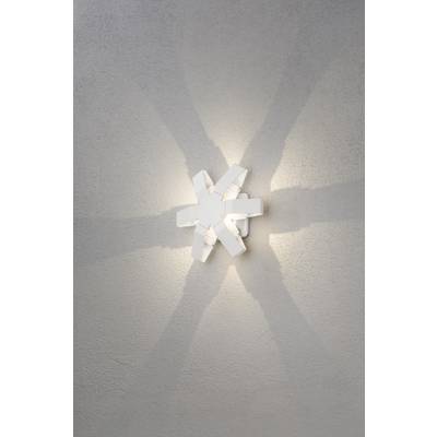 Witte wandlamp met stervormig ontwerp werpt een stervormig patroon van lichtstralen op de grijze muur.