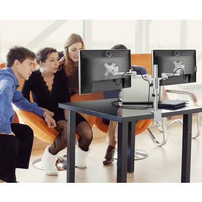 Vier personen kijken geïnteresseerd naar een computerscherm in een modern kantoor met oranje stoelen.