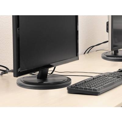 Een computermonitor en een toetsenbord staan op een bureau in een kantoor. Kabels lopen achter de monitor.
