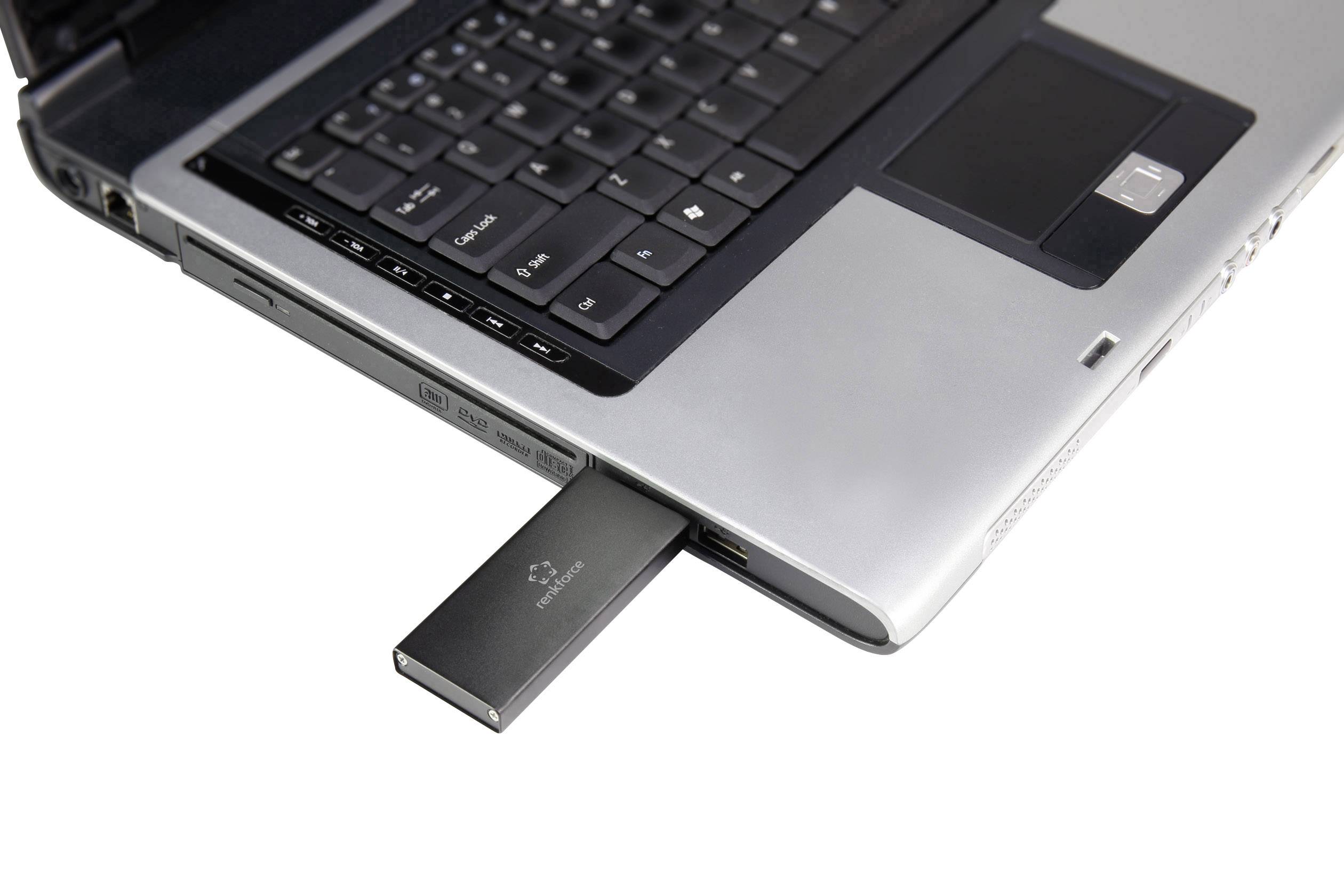 Een zwarte USB-stick is gestoken in de USB-poort van een geopende laptop. De laptop heeft een donkergrijze toetsenbord.