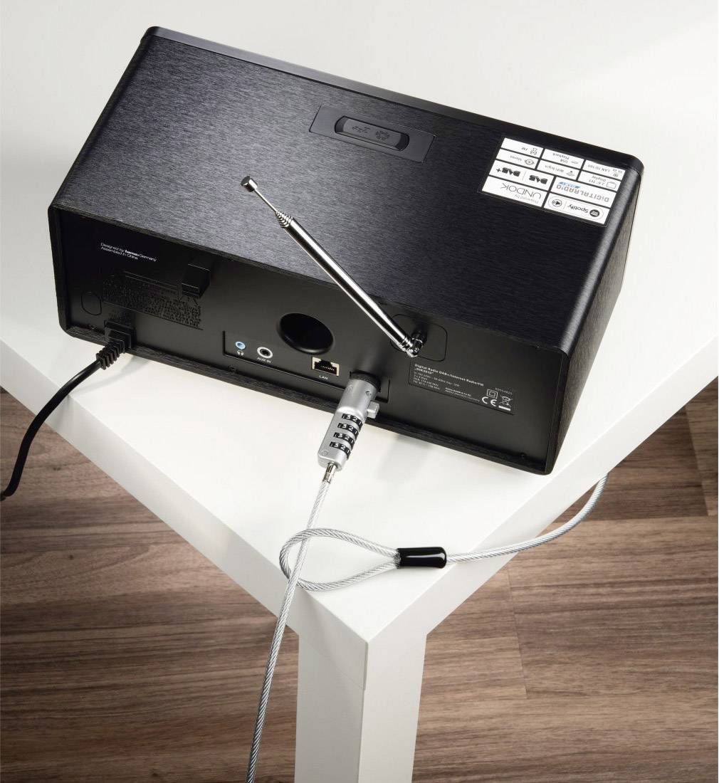 Radio met veiligheidskabel op tafel, achterkant toont aansluitingen en antenne.