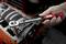 Een hand houdt een momentsleutel van Toolcraft vast, die wordt aangebracht op een motor- of machineonderdeel.