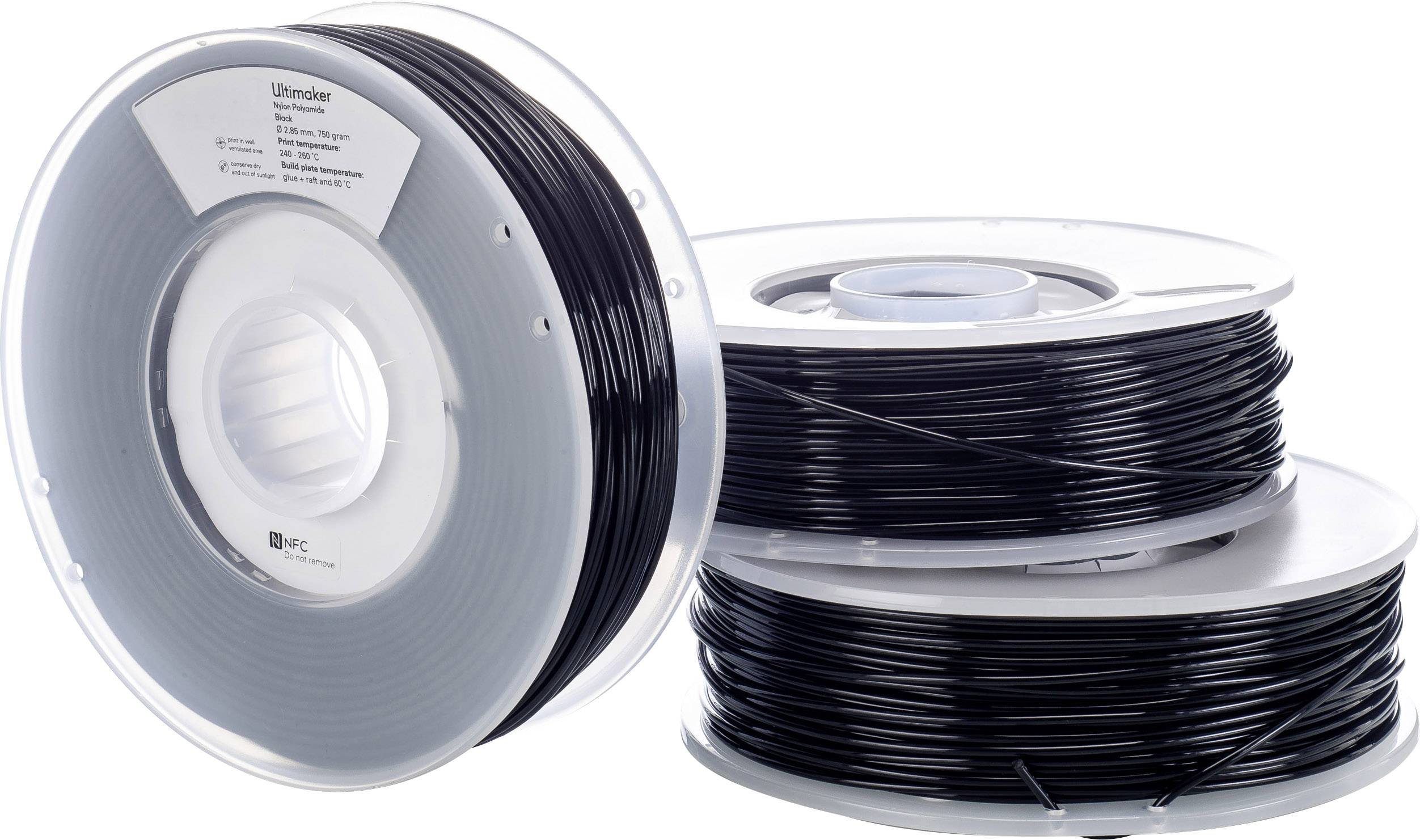 Drie spoelen met zwart 3D-printfilament, gestapeld op een tafel. De linker spoel heeft een etiket met het opschrift 'Ultimaker'.
