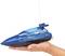 Een hand houdt een blauw op afstand bestuurd modelboot genaamd 'Spring Tide 27' met antenne.