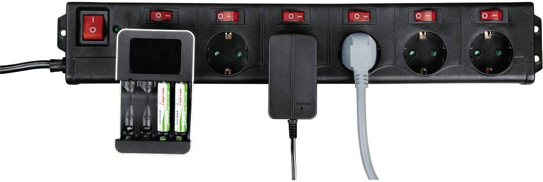 'Zwarte stekkerdoos met zes schakelaars. Twee stekkers zijn aangesloten, één met een zwart snoer, de andere met een grijs snoer. Batterijlader met vier batterijen links ernaast.'