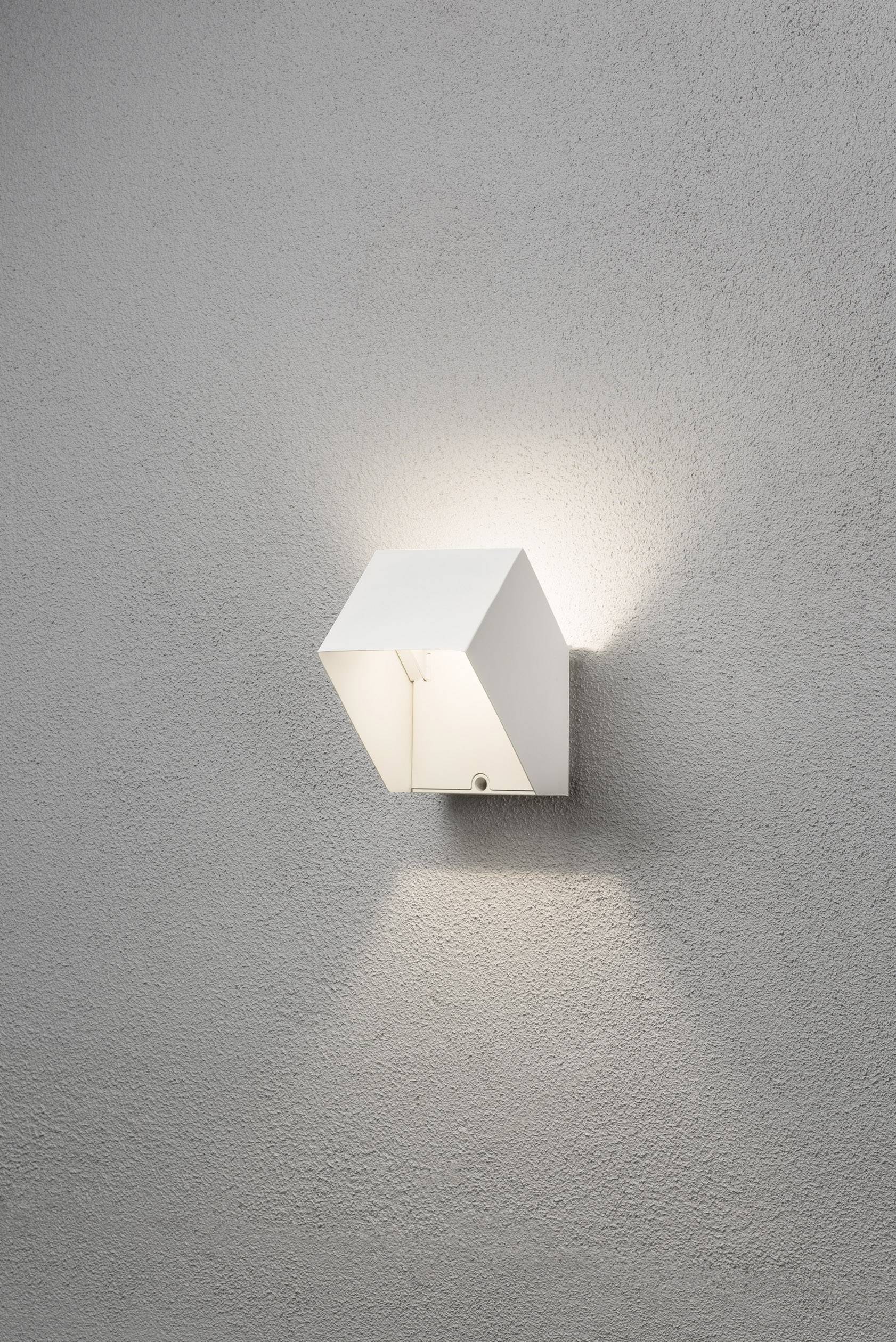 Wandlamp met een modern, kubistisch ontwerp van wit materiaal, gemonteerd aan een grijze muur. Het licht straalt naar boven en beneden.