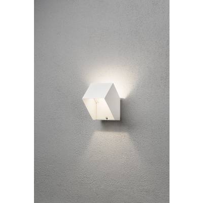 Wandlamp met een modern, kubistisch ontwerp van wit materiaal, gemonteerd aan een grijze muur. Het licht straalt naar boven en beneden.