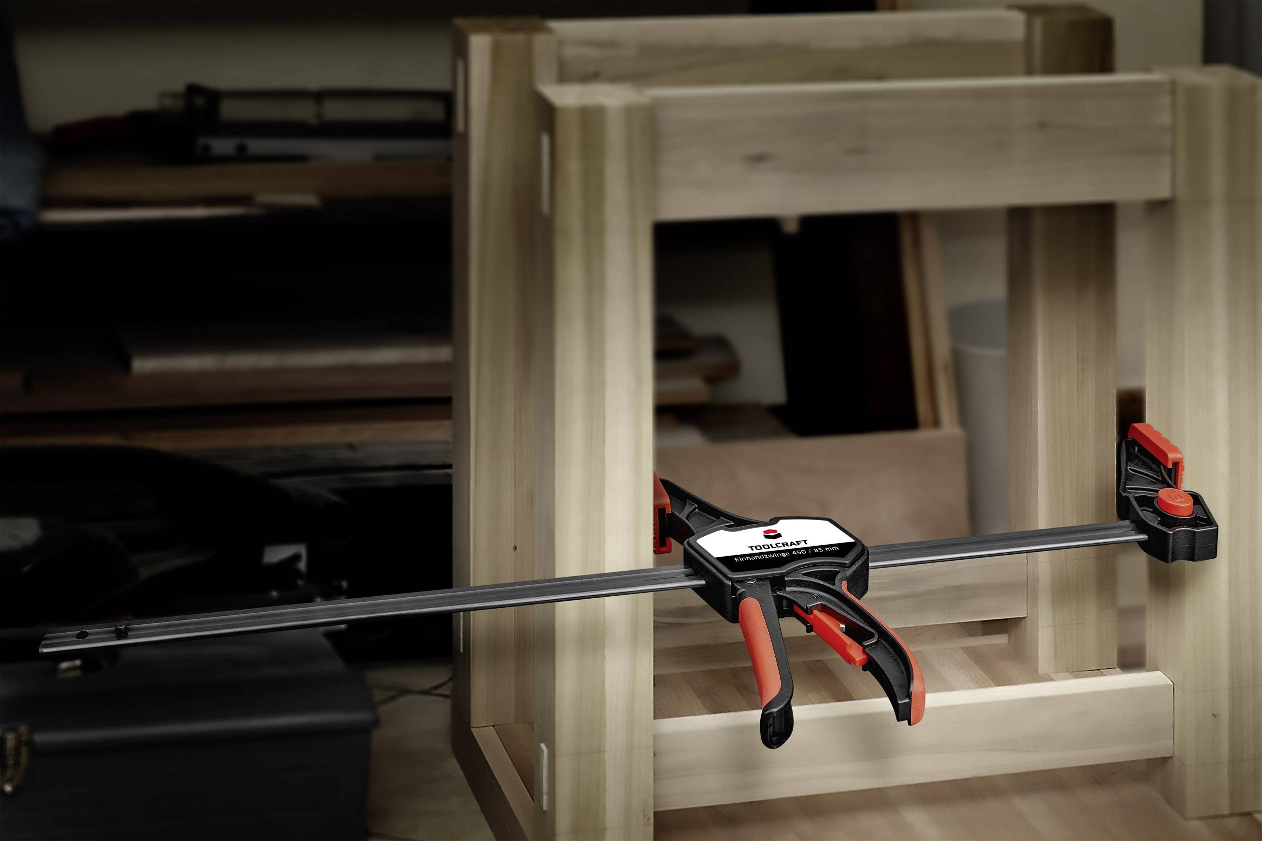 Een werkbank met een houten kist in aanbouw, vastgeklemd met een bankschroef. Op de achtergrond zijn verschillende gereedschappen zichtbaar.