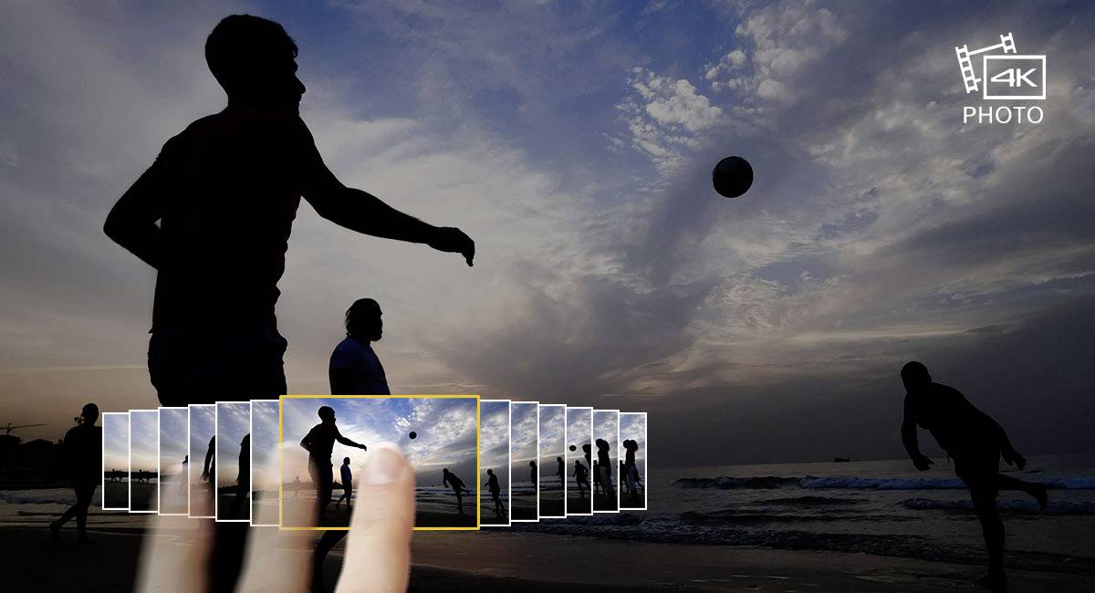 Mensen spelen volleybal op het strand bij zonsondergang. Een hand wijst naar een fotogalerij op de voorgrond.