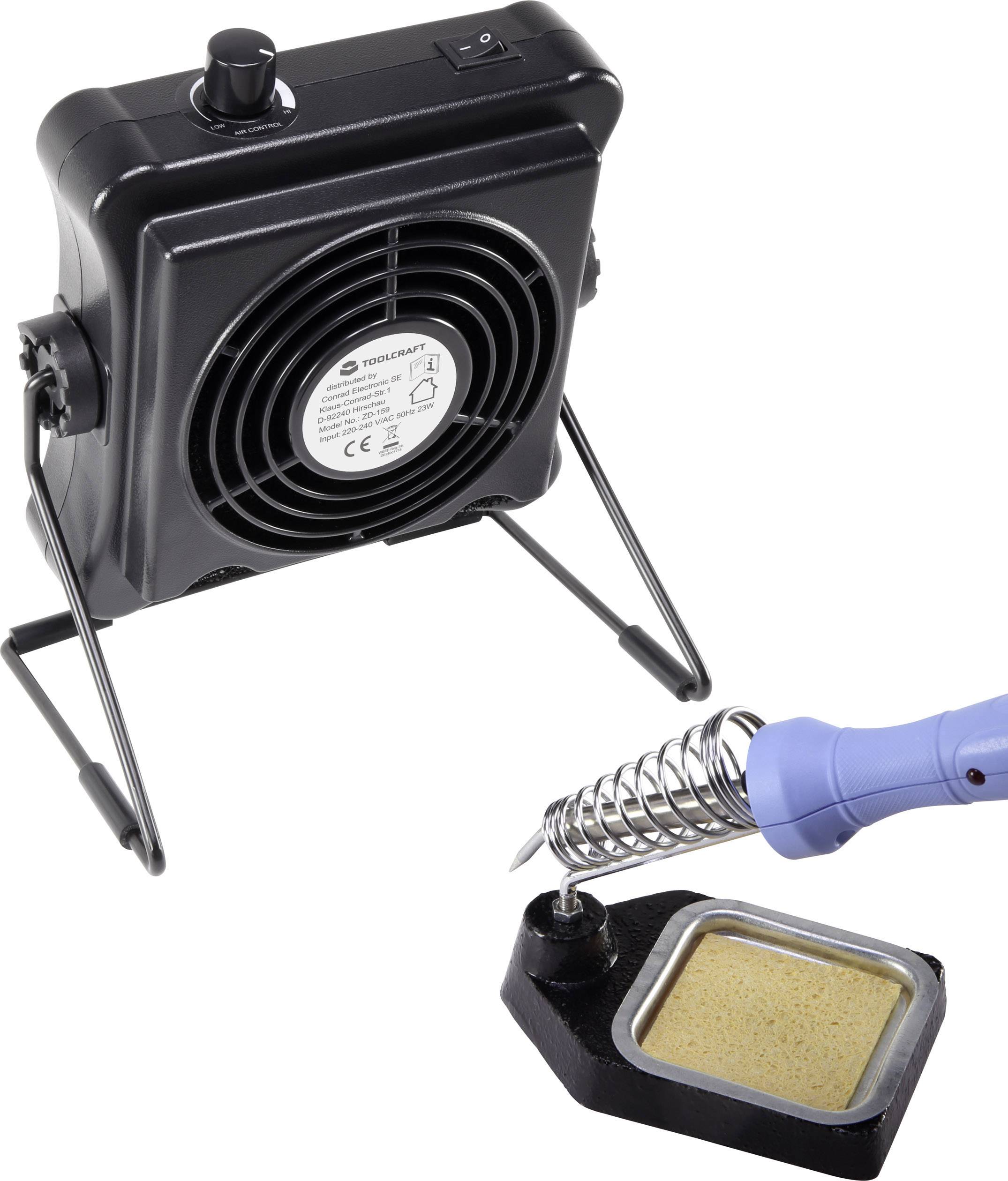 Een soldeerbout in een houder naast een kleine ventilator. De ventilator staat aan om soldeerrook af te voeren.