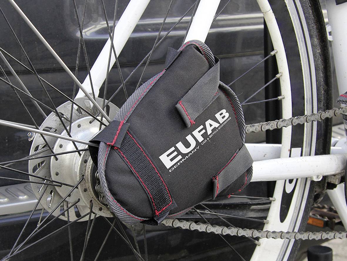 Fietstas van EUFAB bevestigd aan het frame van een witte fiets, dicht bij het achterwiel en de fietsketting.