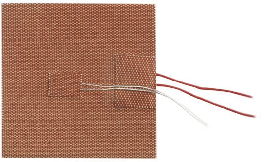 Een vierkant, roodachtig textiel met twee uitstekende draden die afkomstig zijn van een kleiner, aangehecht textieldeel.