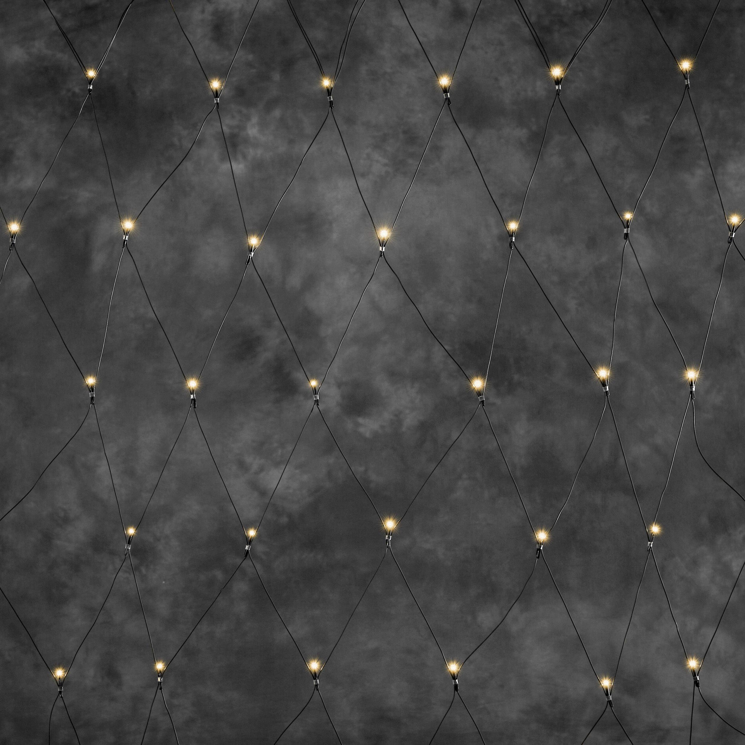 Een zwart draadhekkens met lichtgevende punten op de kruispunten, die een geometrisch patroon vormen tegen een donkere achtergrond.