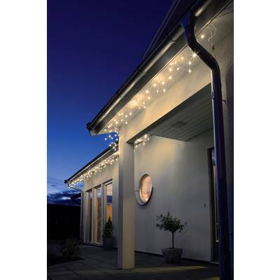 Huis met moderne verlichting: slingers lichten op aan de dakrand van een wit huis in de schemering.