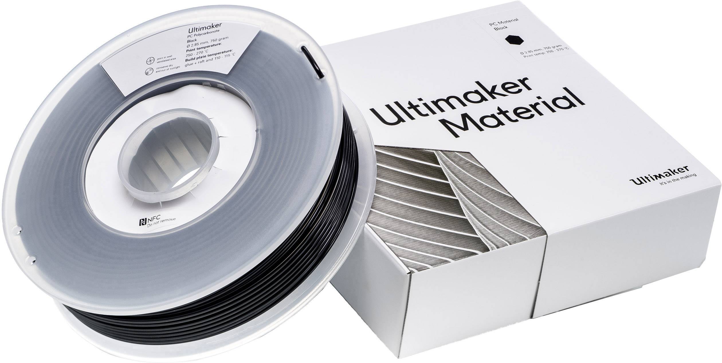 'Ultimaker Material'-spoel in zwart met verpakking. Spoel ligt voor de witte doos met de opdruk 'Ultimaker Material'.