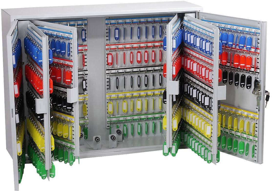 Een open sleutelkast met meerdere haken en veel gekleurde sleutelhangers in de kleuren rood, blauw, geel en groen.