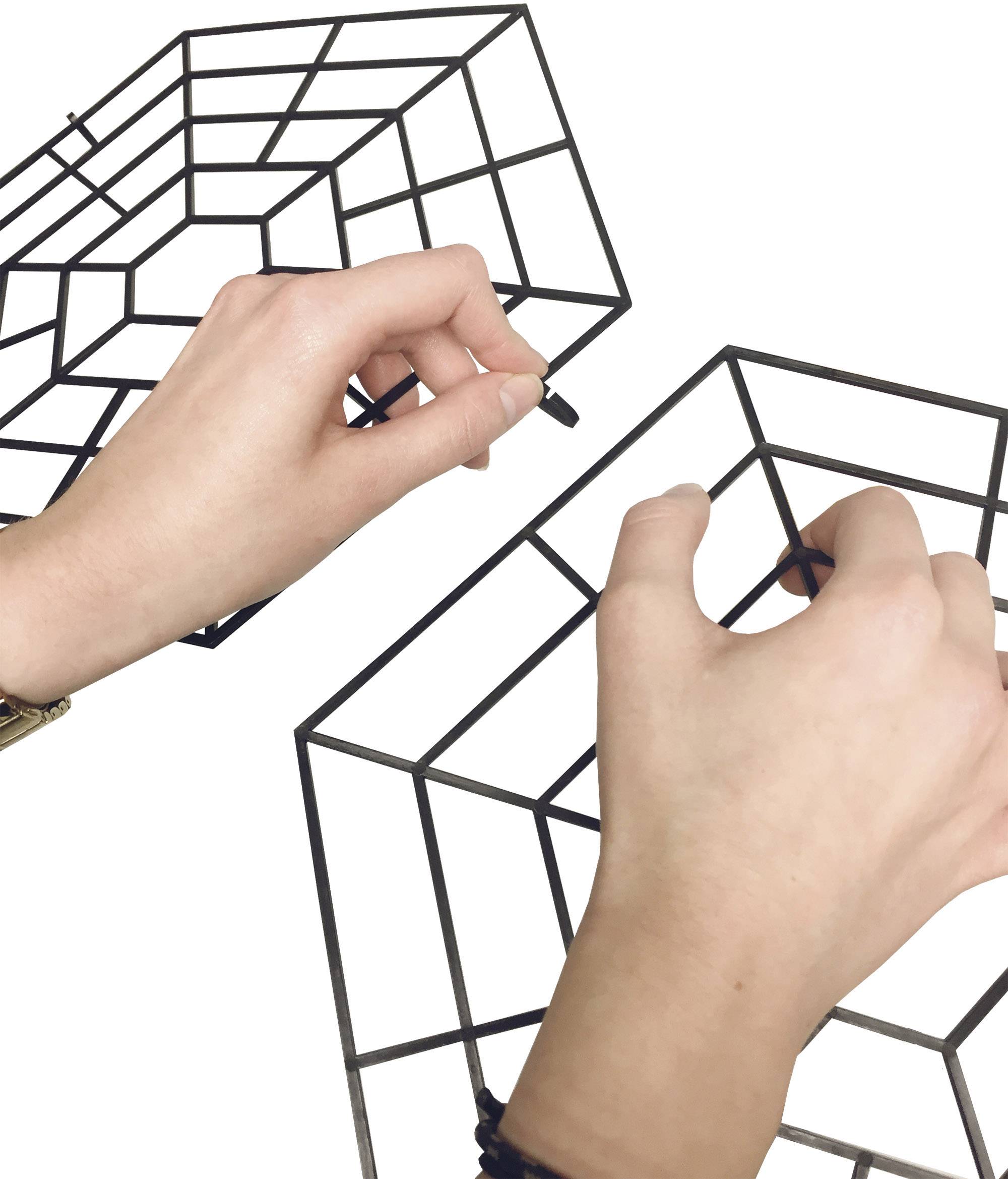 Twee handen tekenen geometrische vormen in de vorm van kubussen.