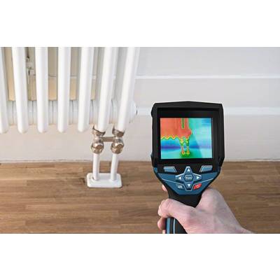 Een persoon houdt een warmtebeeldcamera vast die temperatuurverschillen op een radiator aantoont. Detecteert warmtelekken of inefficiënties.