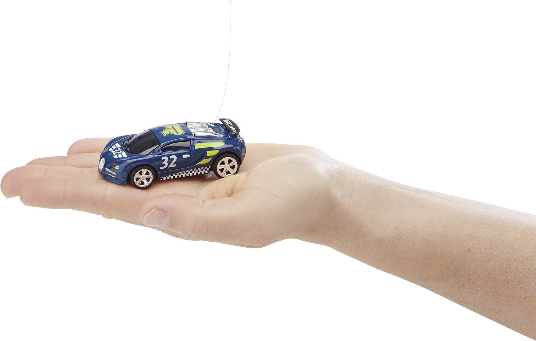 Een hand houdt een kleine speelgoedauto vast, een model van een blauwe raceauto met het nummer '32', op een witte achtergrond.