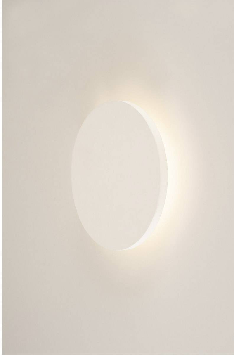 Een witte, ronde lamp aan de muur verspreidt zacht licht.