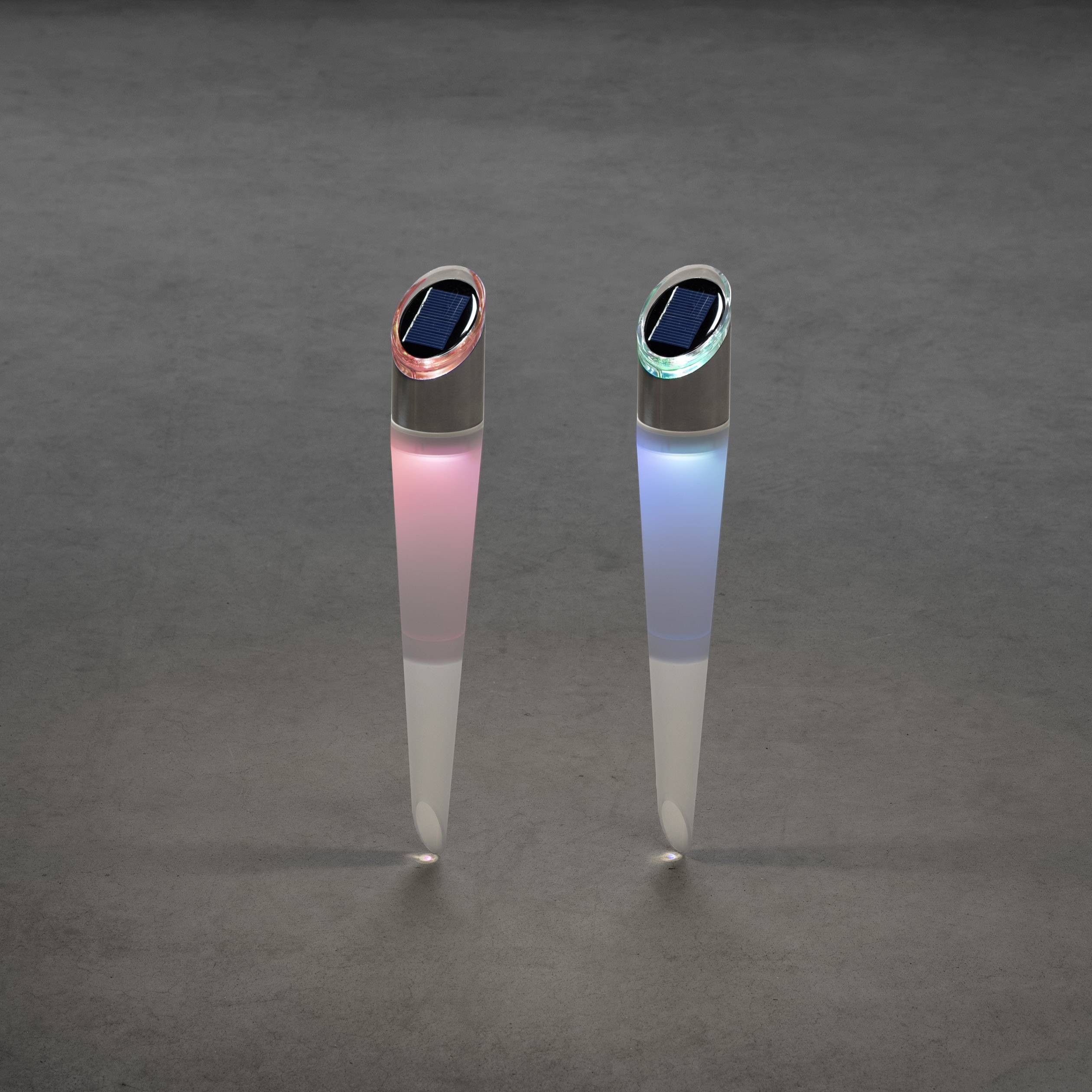 Twee op zonne-energie werkende tuinlampen met rood en blauw licht staan op een grijze ondergrond. Ze zijn gestroomlijnd en stijlvol.