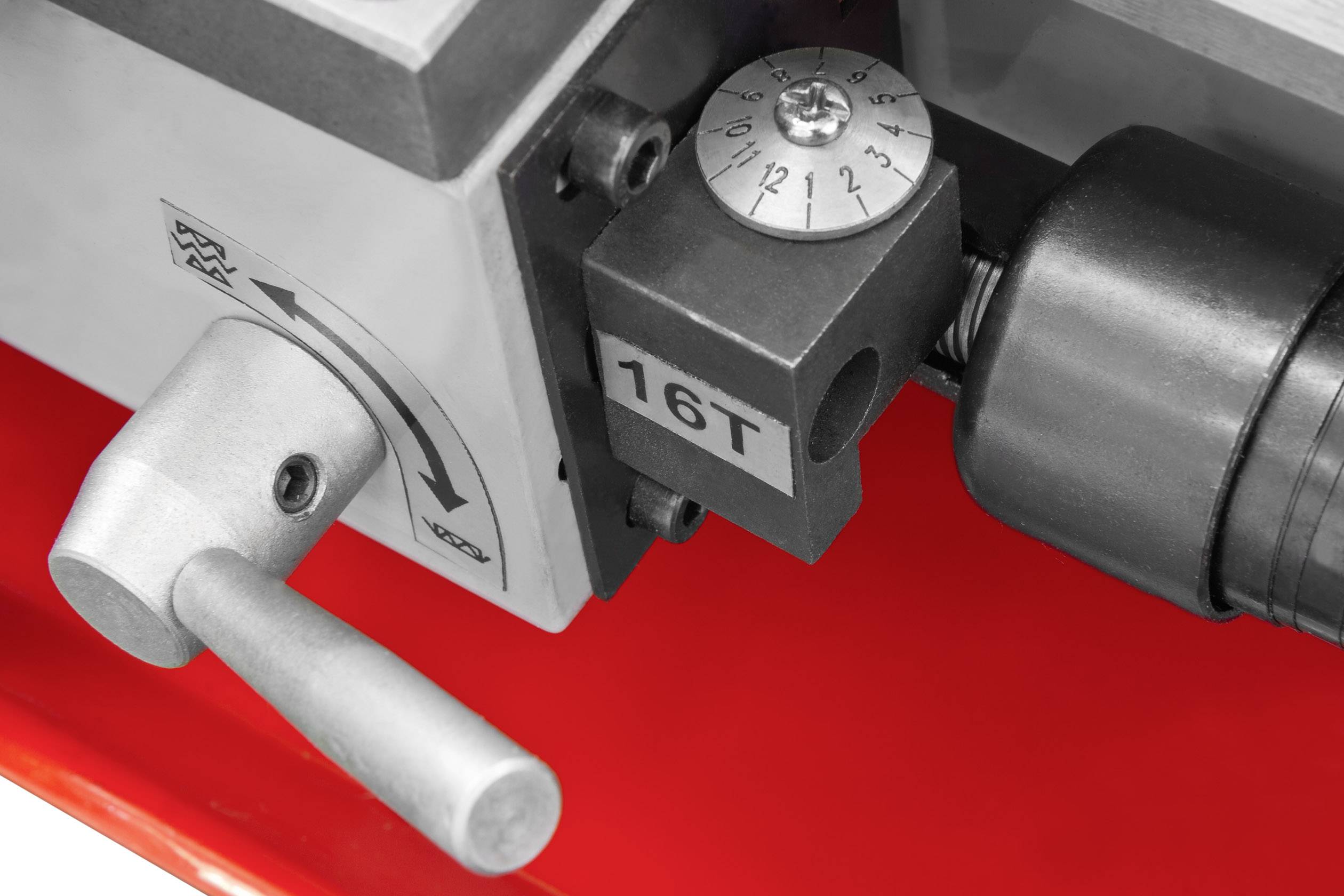 Een draaibankhendel met een schaal op een rond wijzerblad, gemarkeerd met '16T', gemonteerd op een metalen basis met pijlsymbool.