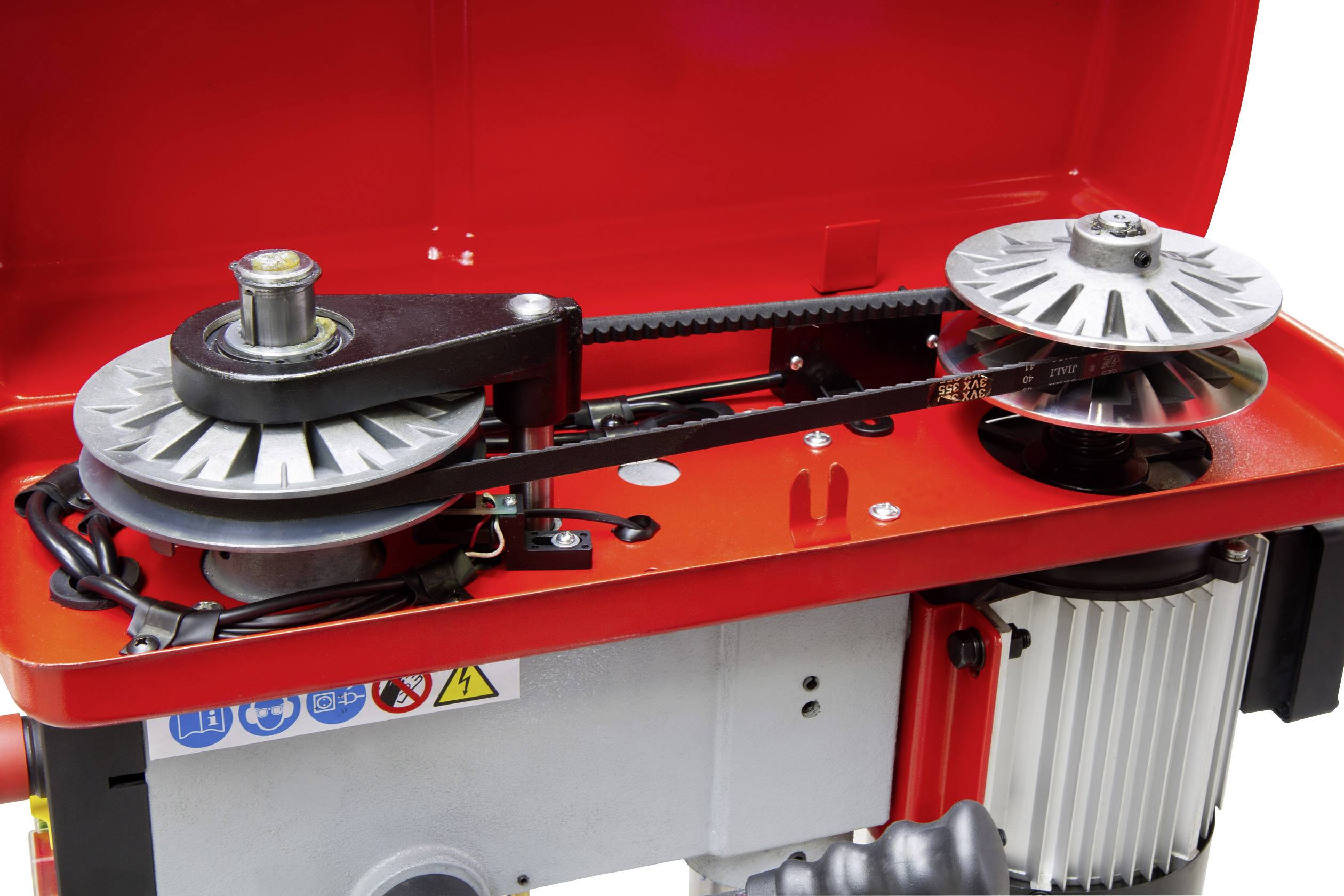 Close-up van een geopend machinemechanisme met een riem-aandrijving en twee riemschijven. De achtergrond toont een rood behuizing.