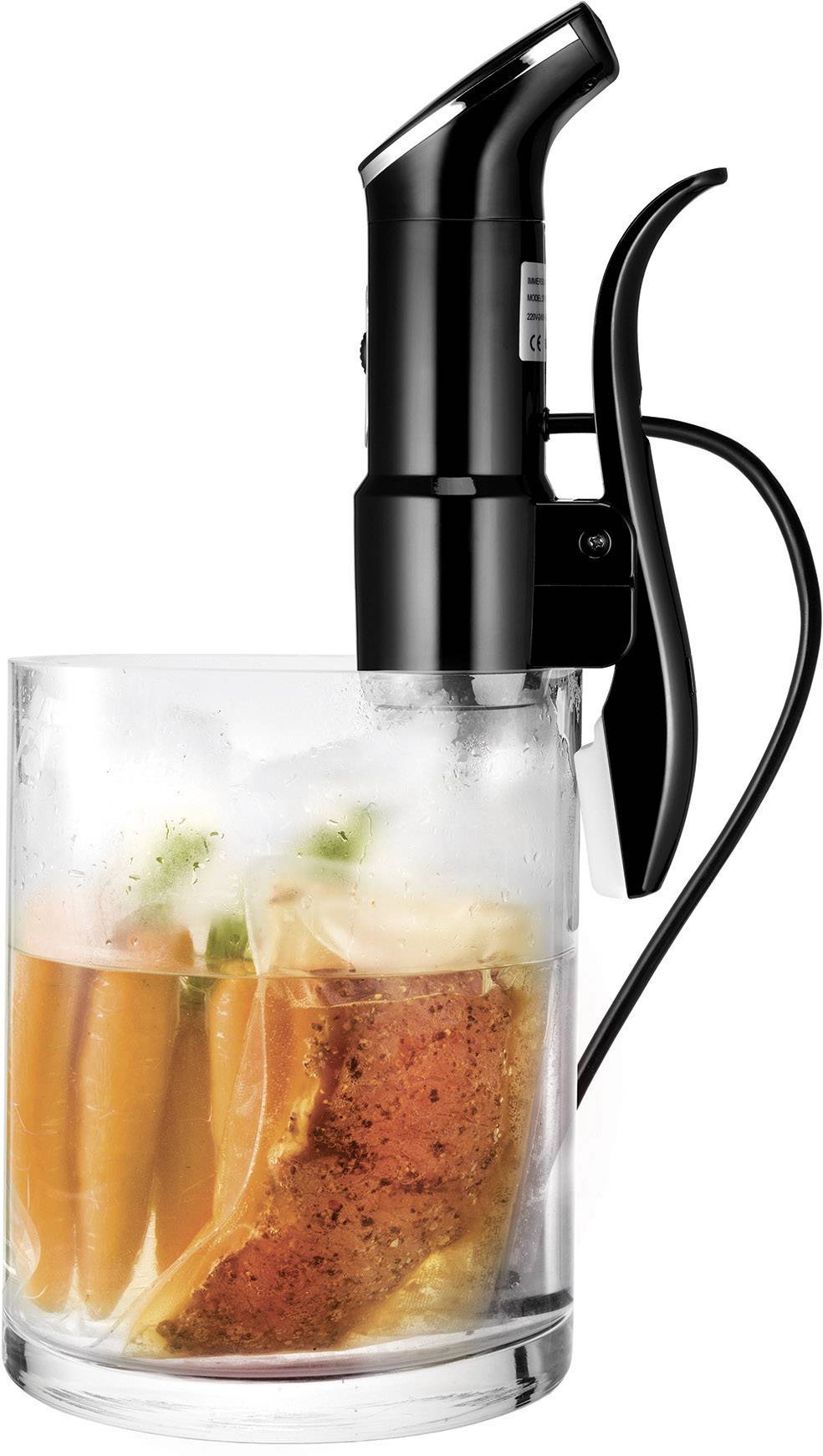 Een sous-vide-staaf in een glazen container met vacuüm verpakte voedingsmiddelen, waaronder wortels en een stuk vlees, wordt verwarmd.