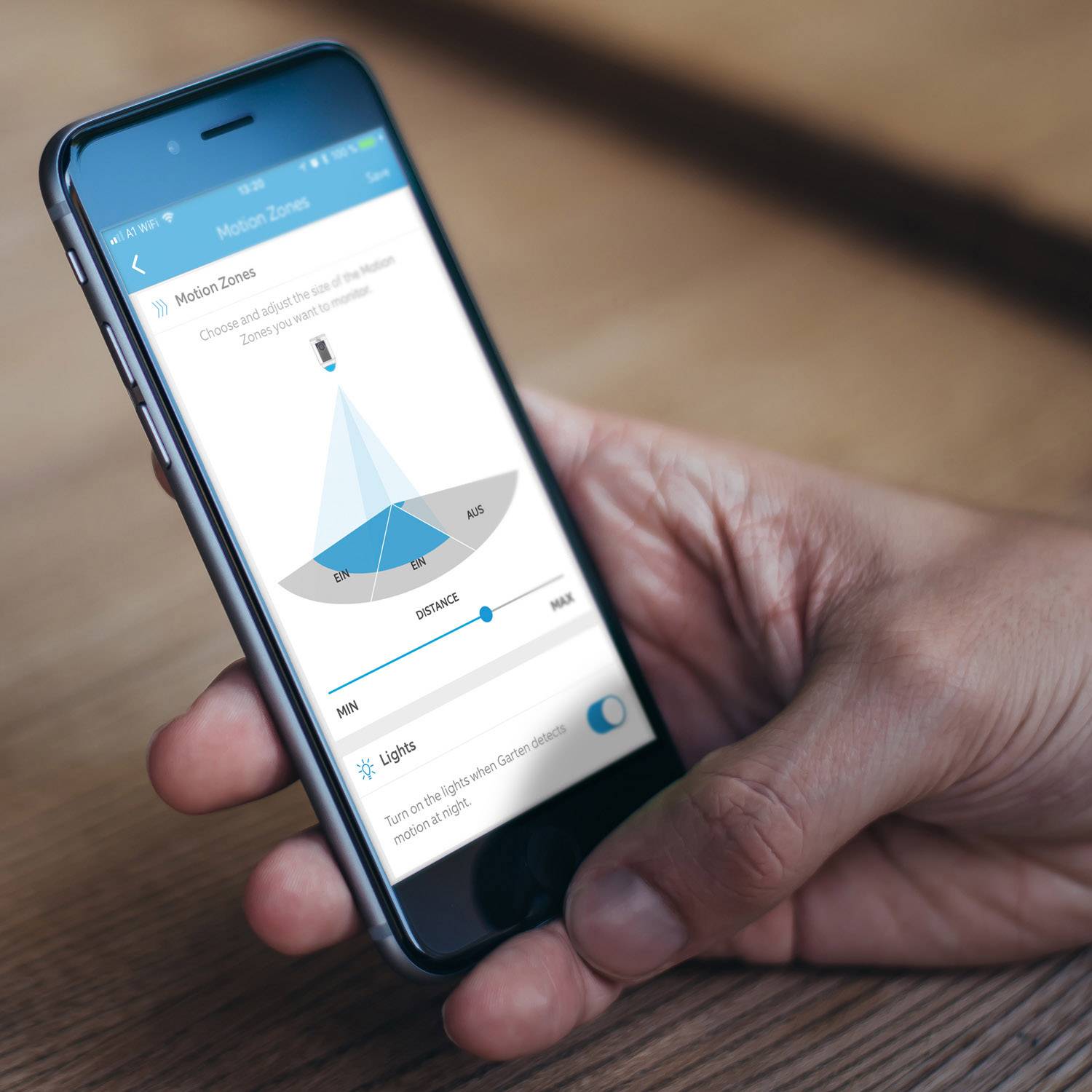 Een persoon houdt een smartphone met een bewegingsherkennings-app in de hand. Het scherm toont een blauwe kegel die beweging detecteert.