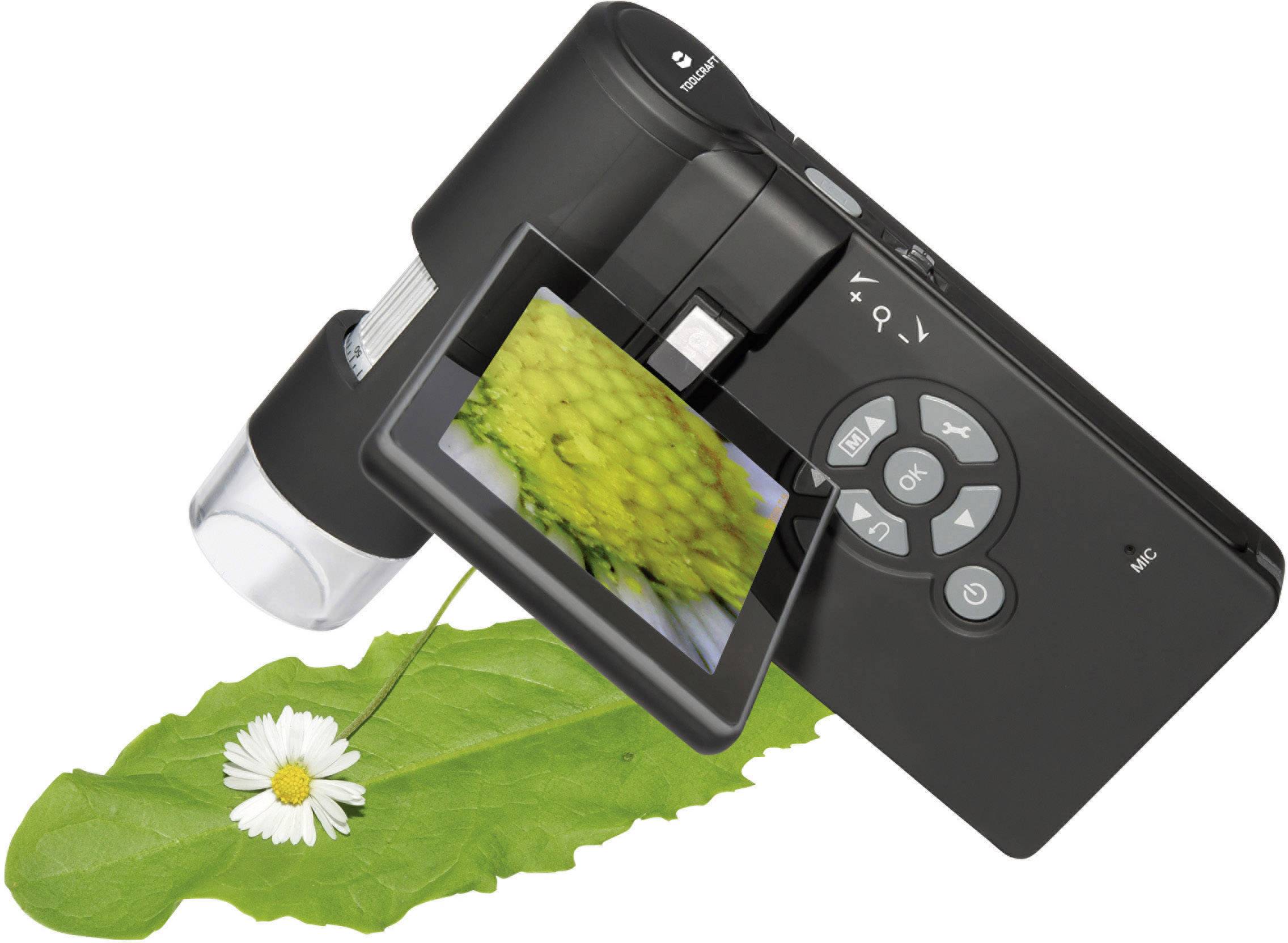 Digitale camera op een groen blad; het display toont een close-up van een gele bloem.
