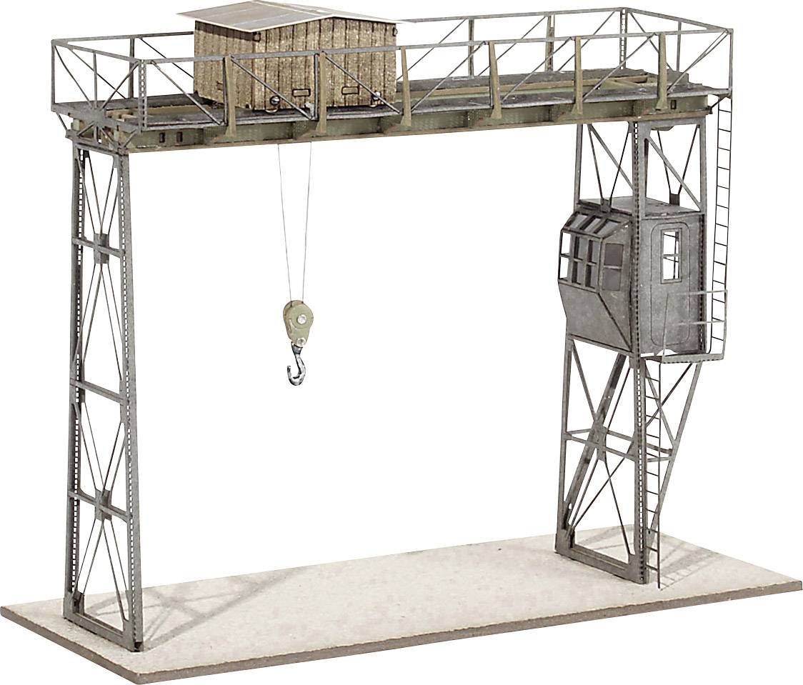 Model van een havenkraan met een haak, een kleine houten hut, een cabine en een metalen platform op een rechthoekige sokkel.