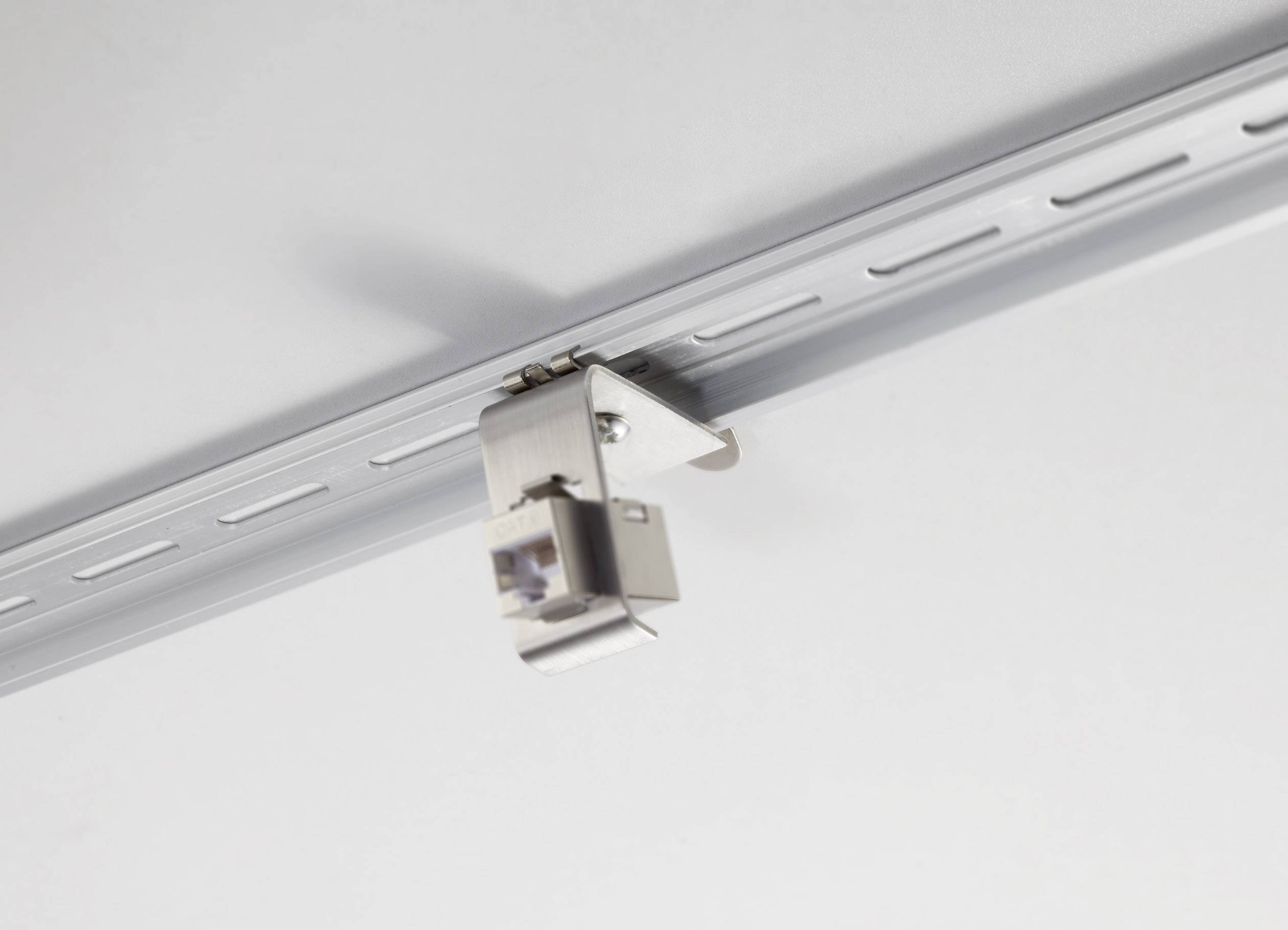 Een plafondrailjsysteem met een gemonteerde, zilveren metalen clip die wordt gebruikt voor bevestiging.