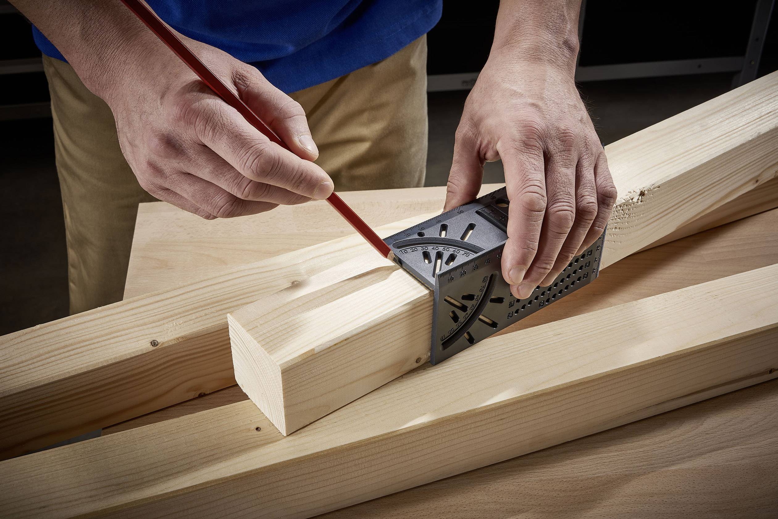 'Hand markeert houten latten met potlood, vastgehouden met een winkelhaak, vermoedelijk voor precisie-afkorten.'