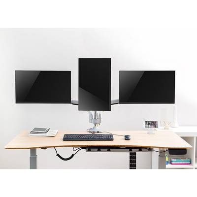 Drie computermonitoren op een in hoogte verstelbaar bureau. De middelste monitor is verticaal geplaatst. Daaronder een toetsenbord.