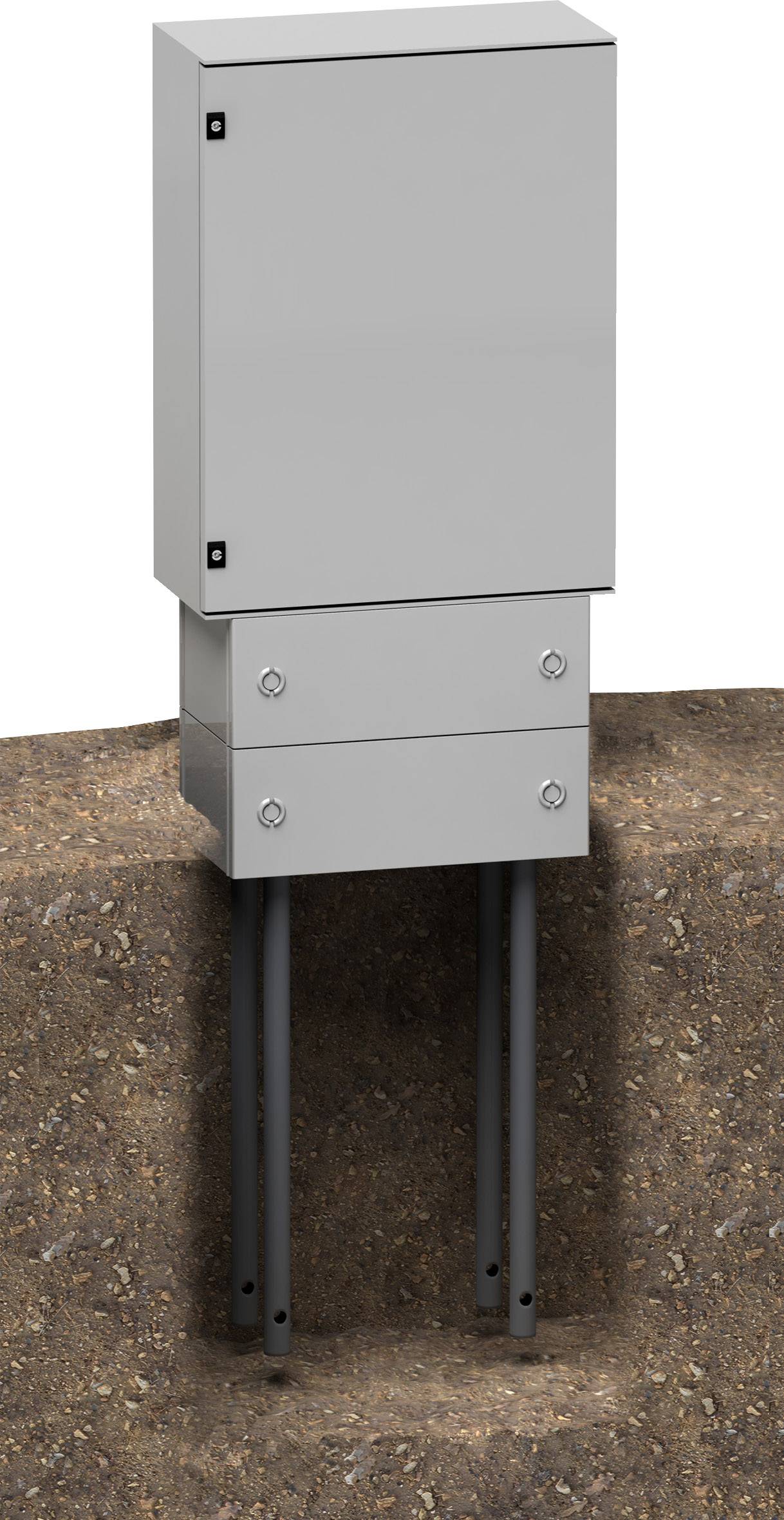 'Een grijze elektrische behuizing is gedeeltelijk in de grond ingegraven. Twee buizen leiden van onderen in de behuizing.'