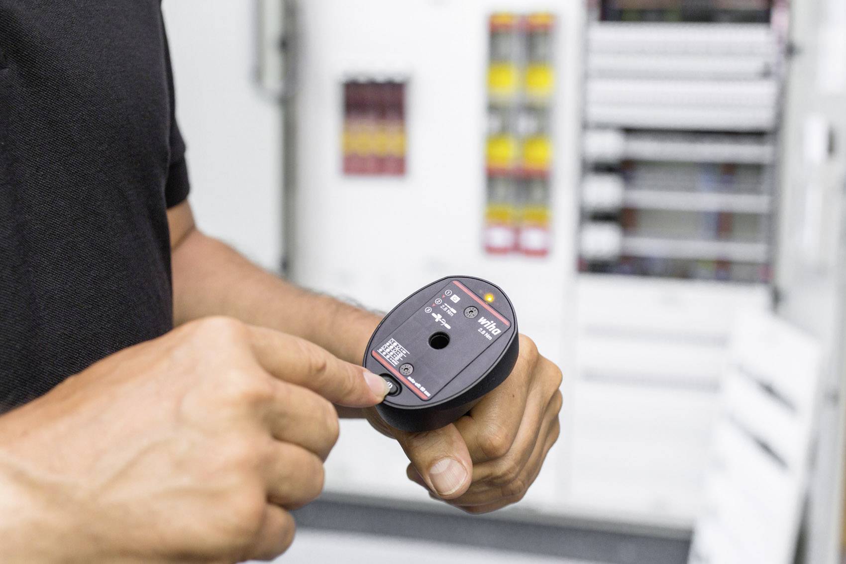 Een persoon controleert met een elektrische meetapparatuur de spanning in een schakelkast.