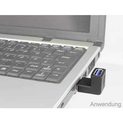 Een laptop met een aangesloten USB-adapter in een USB-poort, zichtbaar boven het toetsenbord.