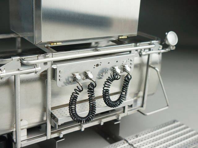 Close-upfoto van een industrieel metalen apparaat met twee spiraalvormige kabels aan de voorkant.