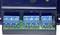 Close-up van een blauwe elektrische aansluitklem op een groene printplaat, met labels 'NO', 'NC', 'C' en spanningsaanduidingen.