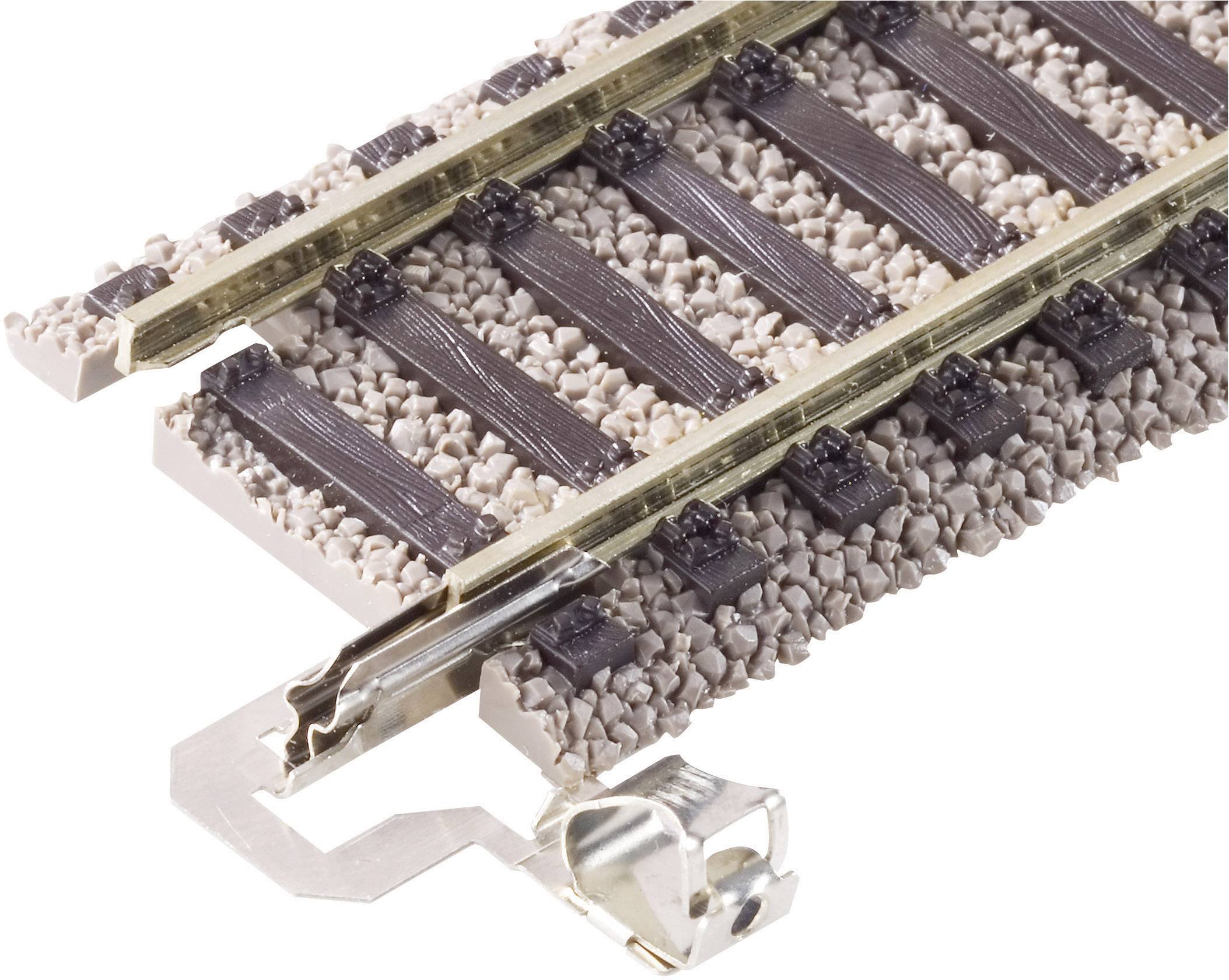 Close-up van een modelspoorrail met rails en dwarsliggers op een stenige ondergrond, geschikt voor modelspoorbouw.