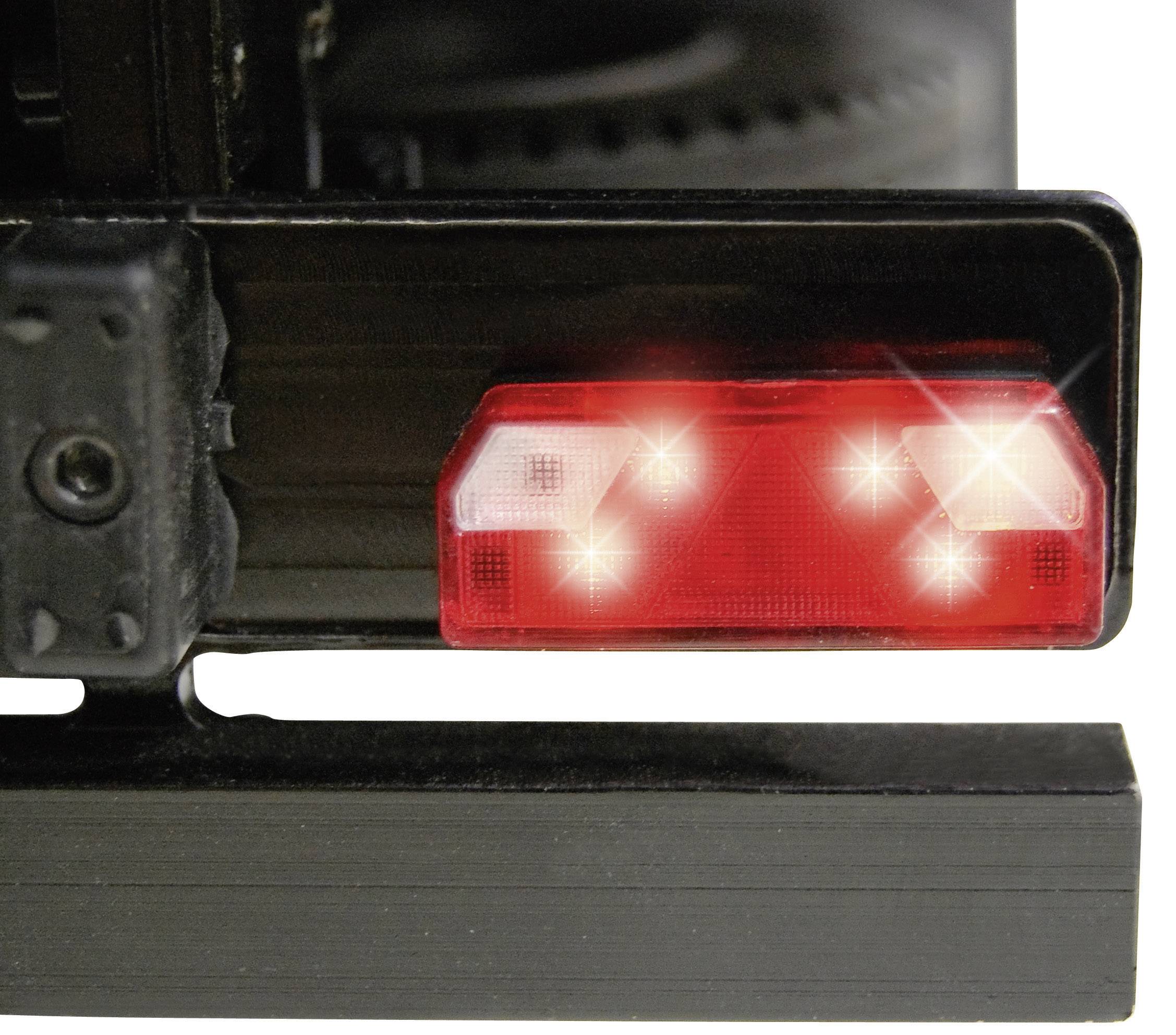 Een rood achterlicht van een voertuig, schijnt helder met vier zichtbare lichtpunten.