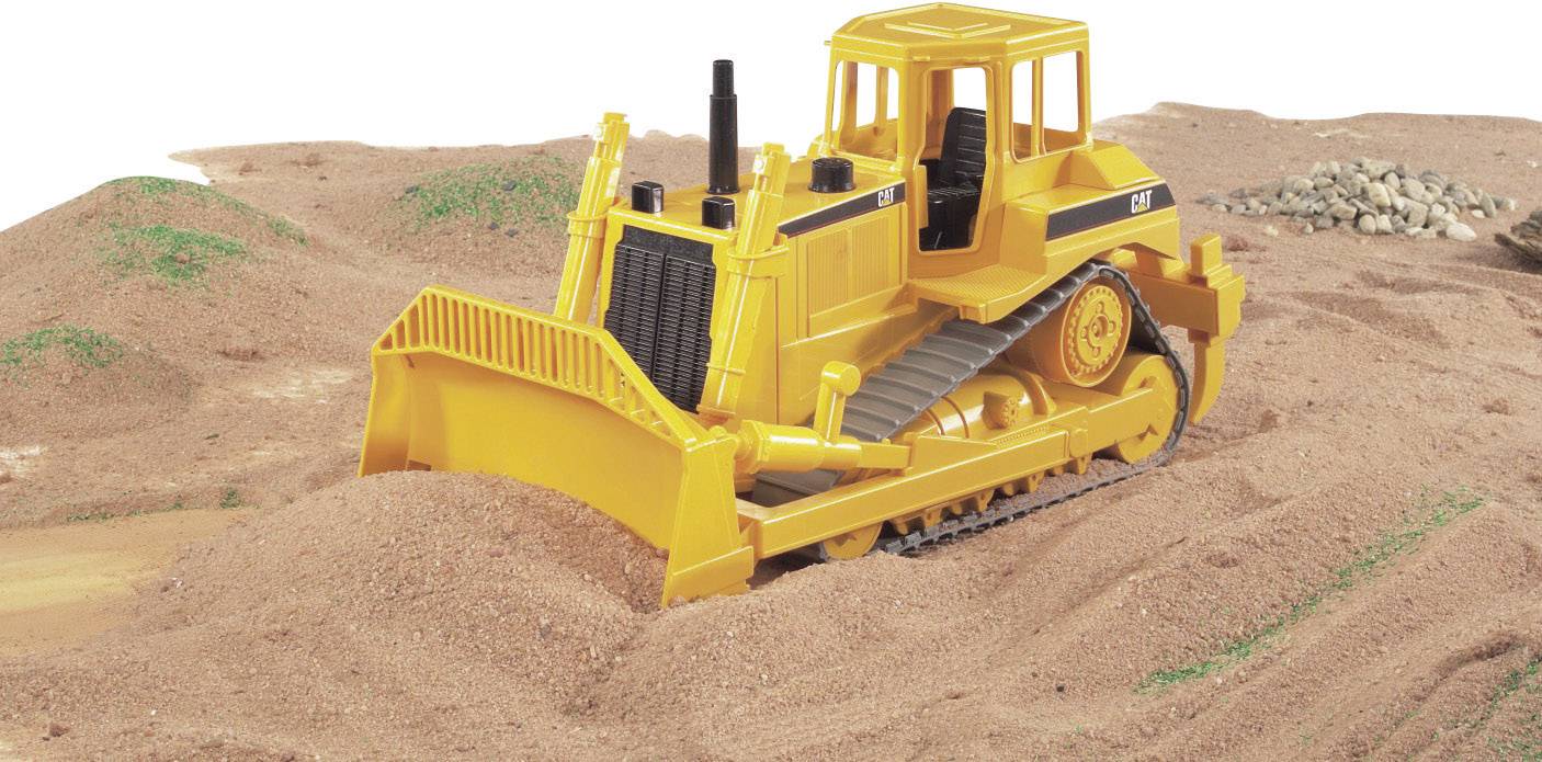 Een gele bulldozer verplaatst grind op een bouwterrein. Op de achtergrond zijn aarde- en grindheuvels zichtbaar.