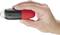 Een hand houdt een rood-zwart apparaat vast, waarschijnlijk een kleine zaklamp of een vergelijkbaar gereedschap.