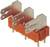 Metalen connectoren op een oranje voet. De connectoren hebben drievoudige aansluitingen en zijn verticaal gepositioneerd.