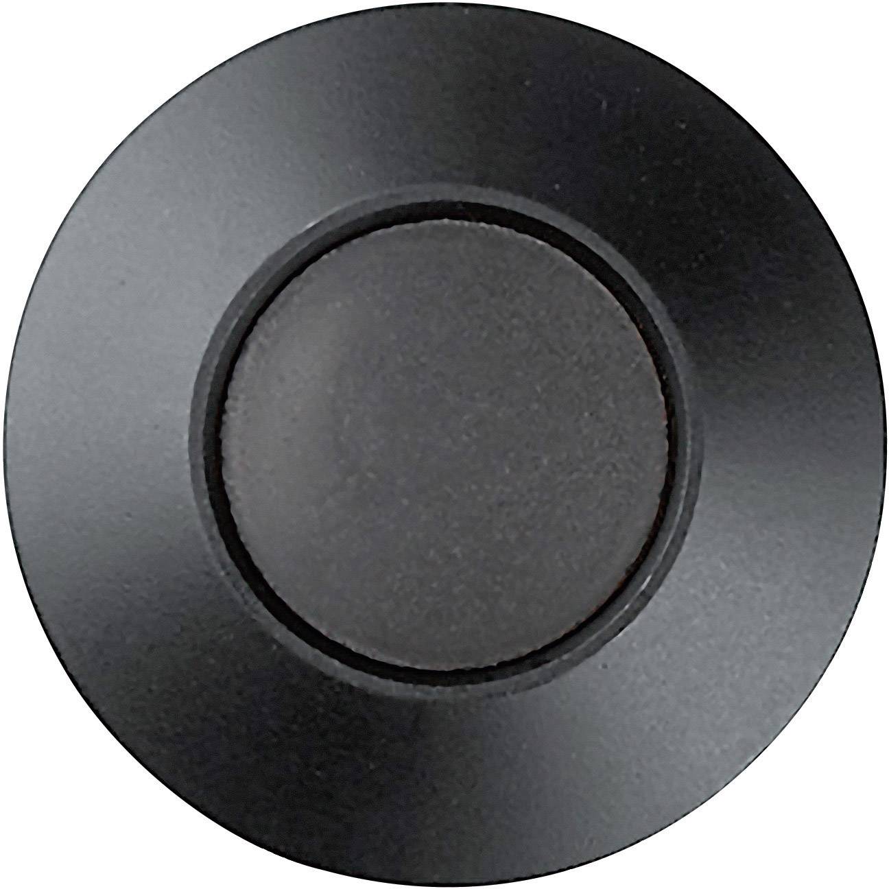Een ronde, zwarte kunststof knop, waarschijnlijk een deur- of belknop, gemonteerd op een gladde oppervlakte.
