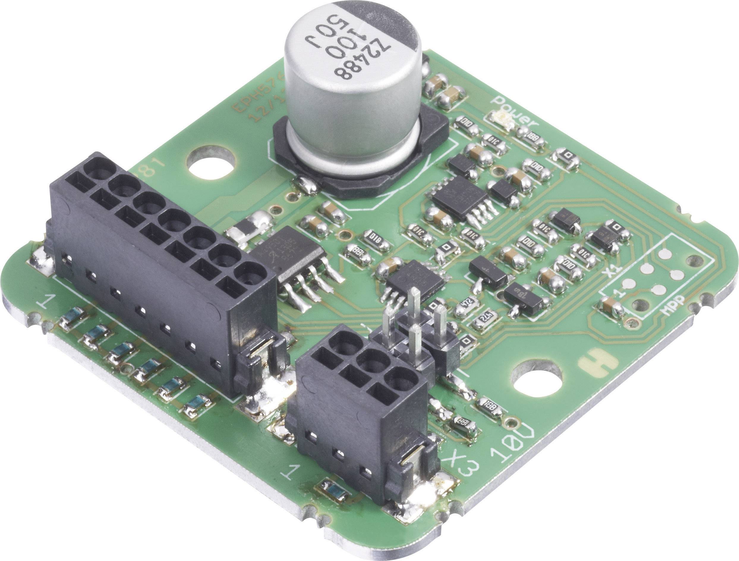 Een groene elektronische printplaat met verschillende elektronische componenten, waaronder een grote zilveren condensator en zwarte connectoren.