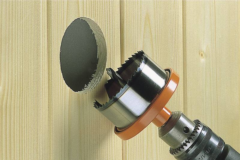 'Boor met gatenzaagopzetstuk boort rond gat in een houten plank.'