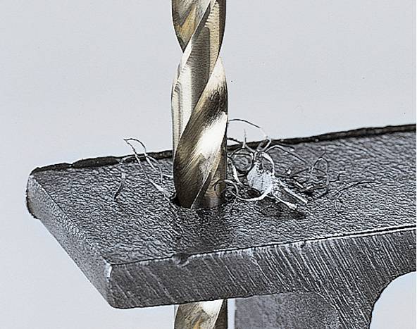 'Een boor doorboort een metalen plaat, spaanders worden gevormd.'