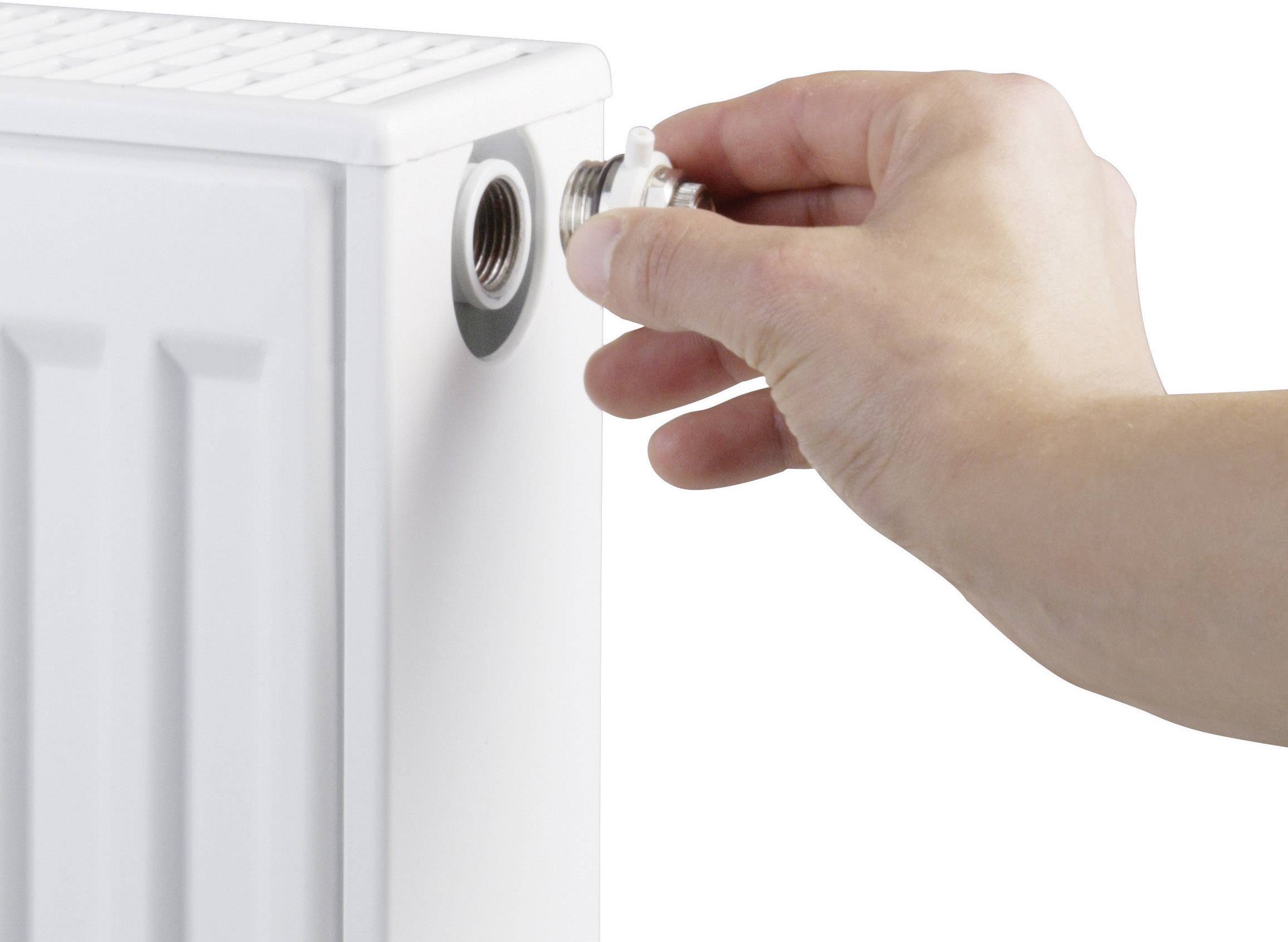 Een hand opent een ventiel aan een radiator, waarschijnlijk om lucht af te laten en de verwarmingsprestatie te optimaliseren.