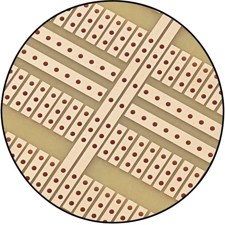 Een close-up van een printplaat-prototype met parallelle koperverbindingen en regelmatige rijen gaten, op een bruine dragerlaag.